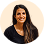 Smiling woman with long dark hair wearing a black top, on a white background.