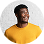 Smiling man wearing a yellow shirt against a white background.